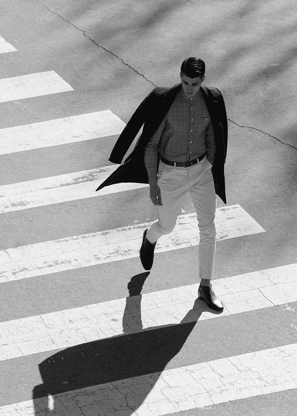 man in suit walking across street