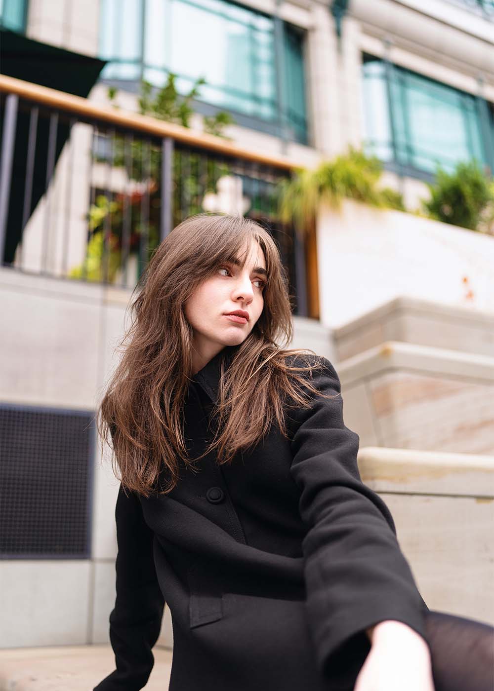 woman sitting on ledge in blazer