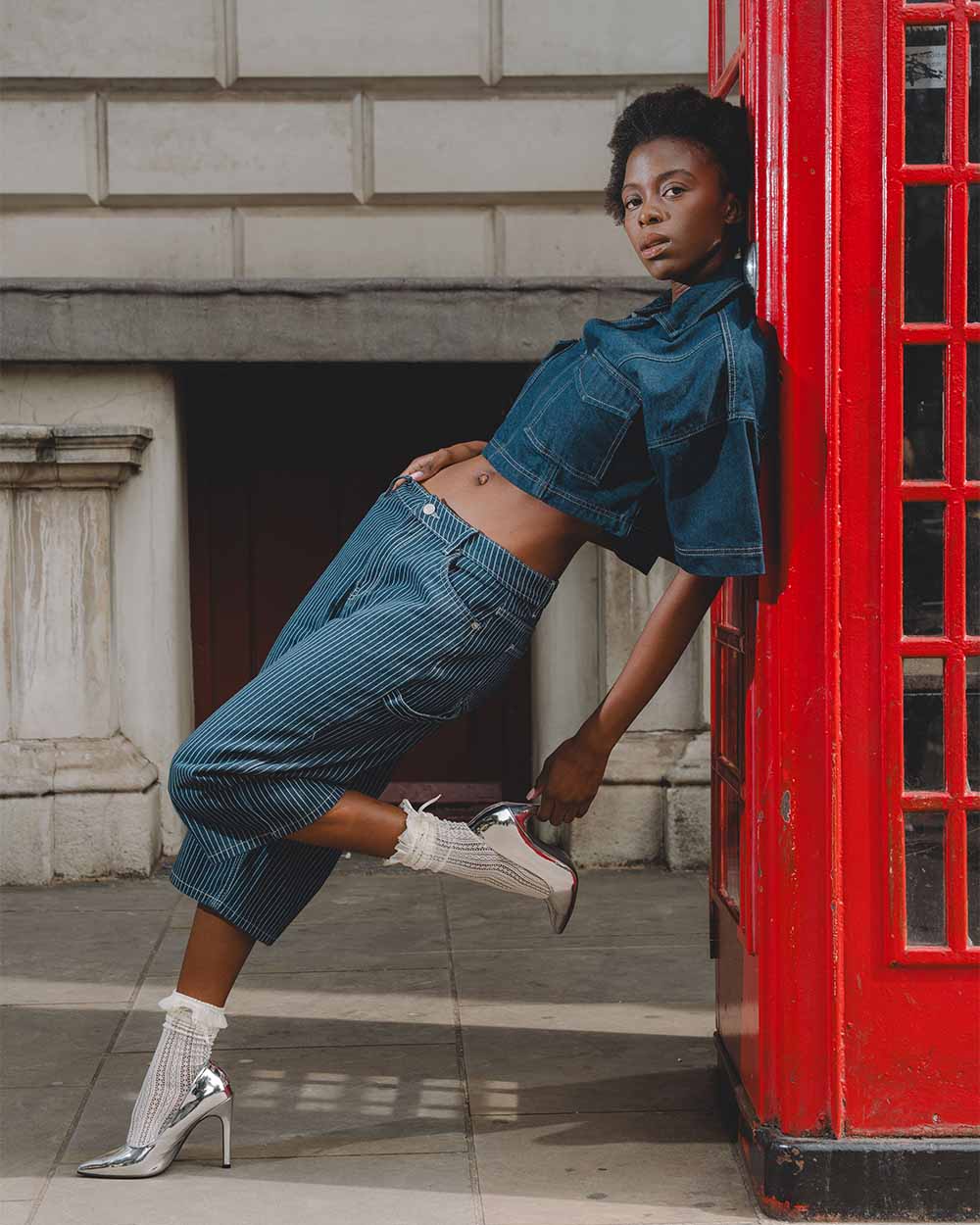 lady leaning against red call box