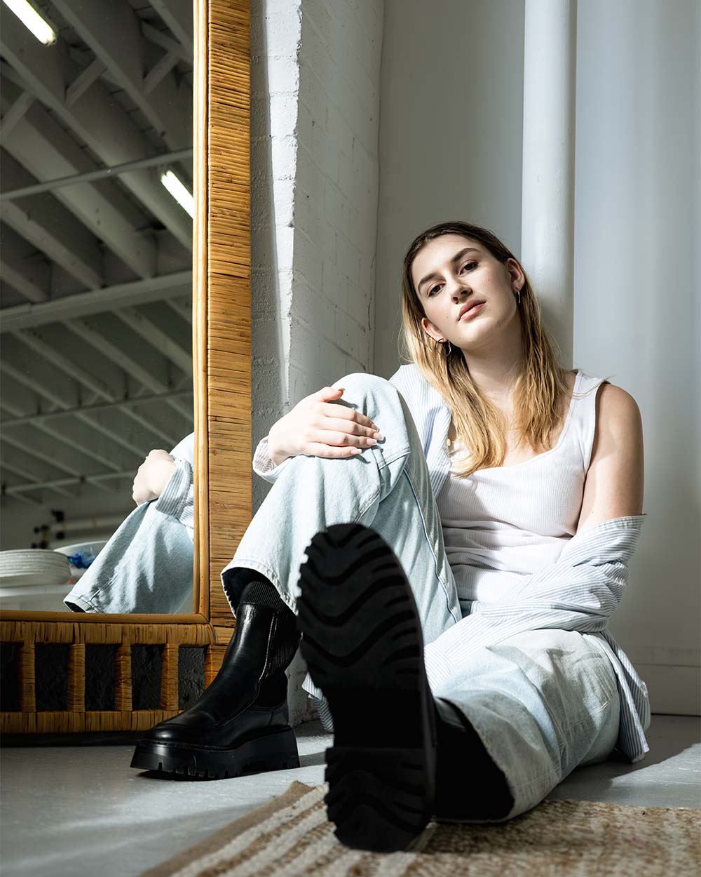girl sitting on ground next to mirror